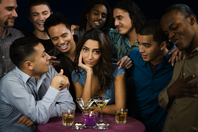 Multi-ethnic men talking to bored woman